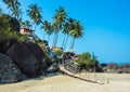 Bright traditional bungalow, standing on a high mountain, against the backdrop of palm trees and bright blue sky, Palolem beach